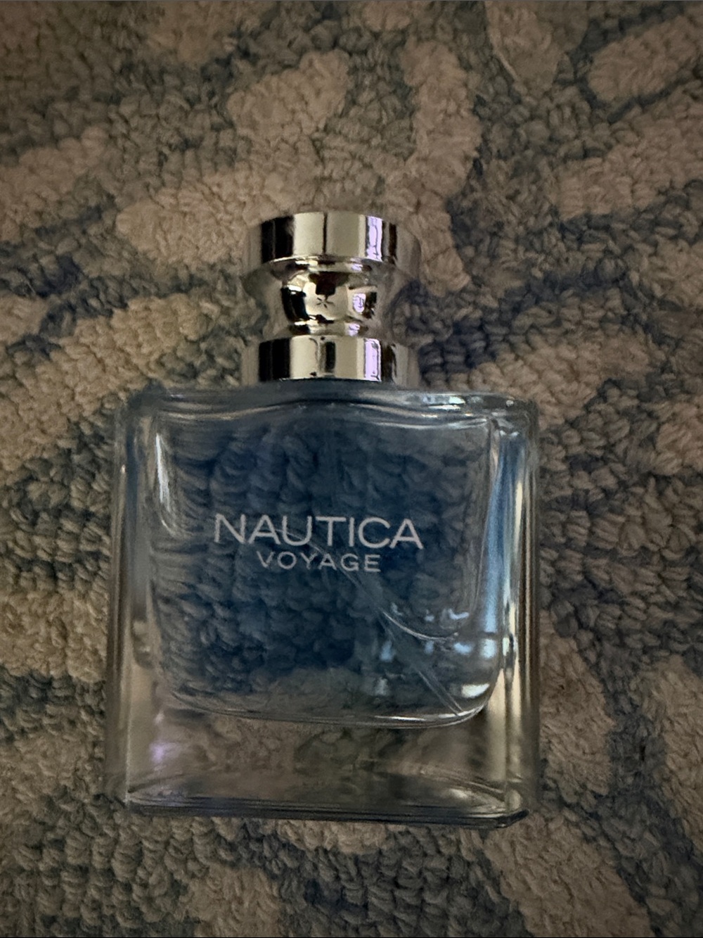Nautica Voyage Clear Bottle with Blue Liquid and Silver Cap